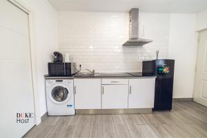 a kitchen with a washing machine and a washer at Aluche Apartments in Madrid