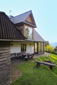 a house with a picnic table and benches in the yard at Domek u Jędrusia in Nowy Targ