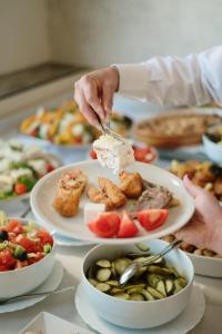 eine Person, die Essen auf einem Tisch mit Tellern isst in der Unterkunft Hotel Slavija in Belgrad