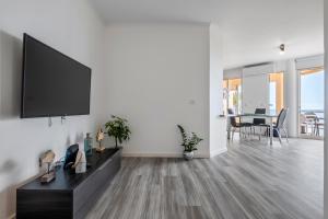 a living room with a flat screen tv on a wall at Magical Sunset in Madalena do Mar