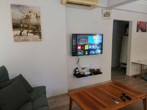 uma sala de estar com uma mesa e uma televisão na parede em Lara Beach 600 m, 80 m2 flat, 2 bedroom, Netflix em Antalya