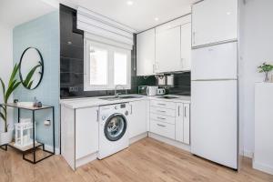 a white kitchen with a washing machine in it at BHost - Tendillas in Córdoba