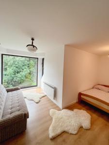 Habitación con 2 camas y ventana con alfombras. en Domek u Jędrusia, en Nowy Targ