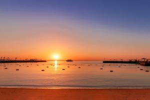 - un coucher de soleil sur une plage avec une jetée dans l'établissement Beach Albatros The Club - Aqua Park, à Hurghada