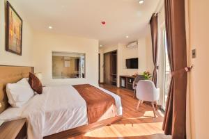 een slaapkamer met een bed en een bureau in een kamer bij Dalat Paradise Hotel in Da Lat