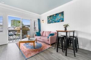 - un salon avec un canapé rose et une table dans l'établissement Villa Vaucluse Apartments, à Cairns