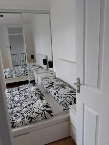 three beds in a room with mirrors at Private 2 Bed Flat close to EXCEL & CITY AIRPORT in London