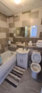 ein Badezimmer mit einer Badewanne, einem WC und einem Waschbecken in der Unterkunft Private 2 Bed Flat close to EXCEL & CITY AIRPORT in London