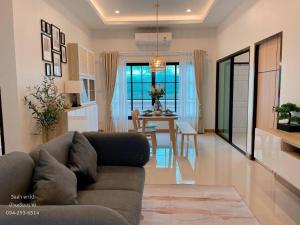 een woonkamer met een bank en een eetkamer bij Guest House Blue Andaman in Phra Ae beach