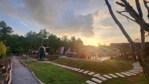 Blick auf einen Garten mit Sonnenuntergang im Hintergrund in der Unterkunft TimeOut Island Glamping Resort in Ấp Binh Trung