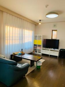a living room with a couch and a table and a tv at homelike / Vacation STAY 33817 in Chiba