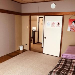 um quarto com uma cama e uma porta de correr em homelike / Vacation STAY 33817 em Chiba