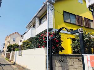 um edifício amarelo com flores ao lado em homelike / Vacation STAY 33817 em Chiba