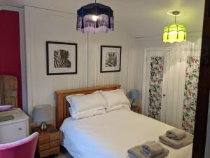 a bedroom with a bed with two towels on it at Lovey Stable mews in hidden location in Royal Tunbridge Wells