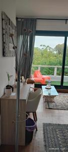 a living room with a couch and a large window at chambre tt confort dans un coin de verdure près de Paris in Le Pecq
