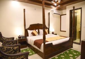 - une chambre avec un lit à baldaquin et un miroir dans l'établissement Staybook Hotel Atlanta New Delhi Train Station, à New Delhi