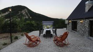 une table et des chaises sur une terrasse avec une montagne dans l'établissement Village Villas, à Şamaxı