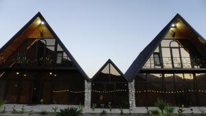un gran edificio de madera con luces en Village Villas en Şamaxı