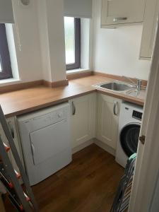 uma cozinha com um lavatório e uma máquina de lavar roupa em May Disc - Long Stay - Contractors em Bristol