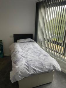 a bed in a bedroom with a large window at May Disc - Long Stay - Contractors in Bristol