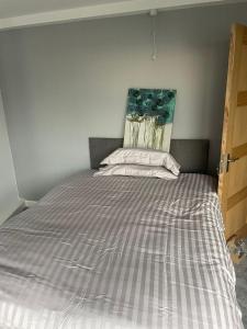 1 cama en un dormitorio con colcha a rayas en May Disc - Long Stay - Contractors en Bristol