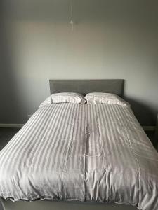 uma cama num quarto com uma parede branca em May Disc - Long Stay - Contractors em Bristol