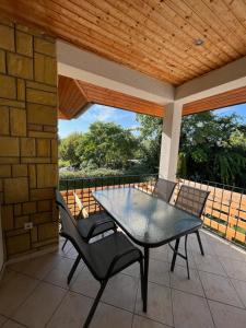 a table and chairs on a patio with a wooden roof at Maja apartmanhàz in Balatonlelle