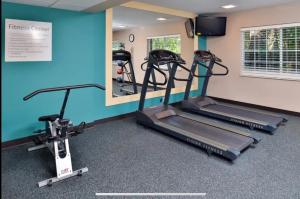 a gym with two tread machines and a mirror at Red Roof Inn PLUS & Suites Tampa in Tampa