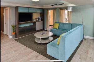 a living room with a blue couch and a table at Red Roof Inn PLUS & Suites Tampa in Tampa