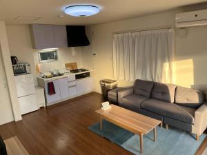 ein Wohnzimmer mit einem Sofa und einem Tisch in der Unterkunft Methodnet Hanazono B / Vacation STAY 77522 in Chiba