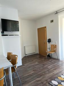 a room with a table and chairs and a television at Maja apartmanhàz in Balatonlelle