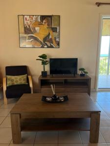 a living room with a coffee table and a tv at Xenia's Seaview House in Paralía Avlídhos