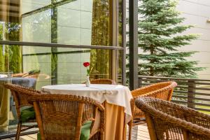 a table with a rose on it on a balcony at VILNIUS PARK PLAZA HOTEL, Restaurant & Terrace, Panorama Bar, Conference & Banquet Center in Vilnius