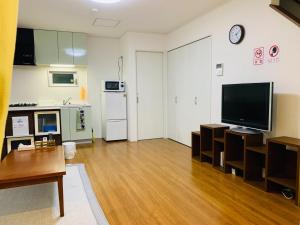 a living room with a large television and a kitchen at Maisonette Hanazono - Vacation STAY 97278v in Chiba