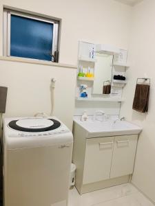 a small bathroom with a sink and a washing machine at Maisonette Hanazono - Vacation STAY 97278v in Chiba