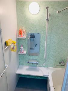 uma casa de banho com um chuveiro, uma banheira e um lavatório. em Maisonette Hanazono - Vacation STAY 97278v em Chiba