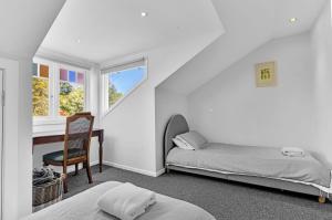Un dormitorio con dos camas y un escritorio y una silla. en Twenty 2 Abbey, en Leura 49 fotos más