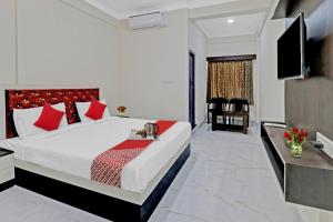 a bedroom with a large bed with red pillows at OYO Nra Residency Near Rajarajeshwari Nagar Metro Station in Bangalore
