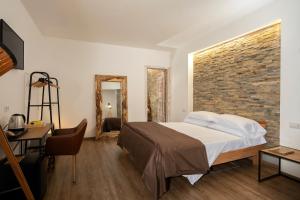 - une chambre avec un lit et un mur en briques dans l'établissement alle Stelle b&b, à Anacapri