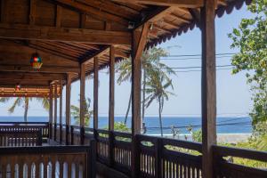 een uitzicht op het strand vanaf de veranda van een strandhuis bij Jukung Cottage in Nusa Penida