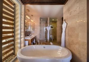 ein Badezimmer mit einer Badewanne, einem WC und einem Waschbecken in der Unterkunft Grand Luxxe Two Bedroom Villa- Nuevo Vallarta in Nuevo Vallarta