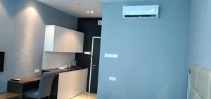 a kitchen with a table and a blue wall at PINTARMAN SERVICE APRTMENT @ THE STIRLING SUITES in Miri