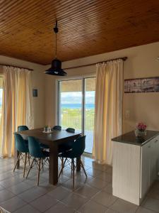 a dining room with a table and chairs and a large window at Xenia's Seaview House in Paralía Avlídhos