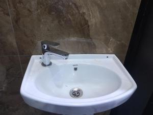 a white sink with a faucet in a bathroom at Peace Hut in Nadi