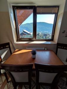 a wooden table and chairs in a room with a window at Садиба АнноМарі - відпочинок в Карпатах котедж Яремче in Yaremche