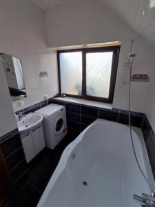 a bathroom with a tub and a toilet and a sink at Садиба АнноМарі - відпочинок в Карпатах котедж Яремче in Yaremche