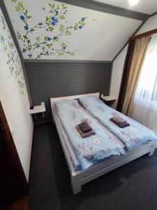 a bedroom with a bed with blue flowers on the wall at Садиба АнноМарі - відпочинок в Карпатах котедж Яремче in Yaremche