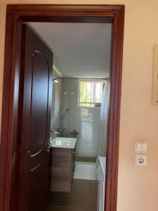 a bathroom with a shower and a sink and a mirror at Xenia's Seaview House in Paralía Avlídhos