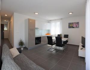 a kitchen and living room with a couch and a table at Apartments Diamond in Podstrana