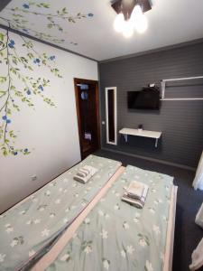 - une chambre avec un lit orné de fleurs sur le mur dans l'établissement Садиба АнноМарі - відпочинок в Карпатах котедж Яремче, à Yaremtche